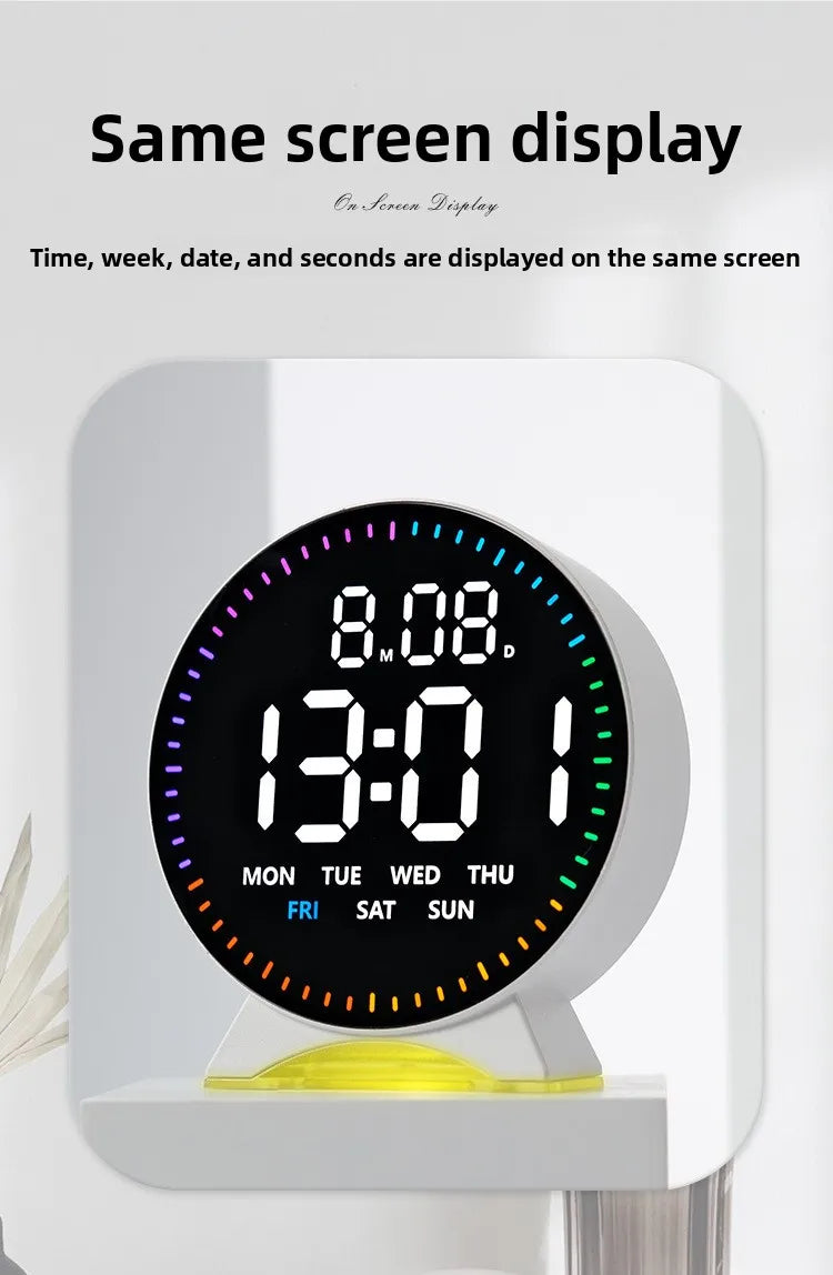 A round digital clock display showing the time 13:01 and days of the week, mounted on a white wall.