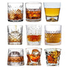 A collection of various whiskey glasses, including rocks glasses and tumblers, showcasing different styles and amber liquid.