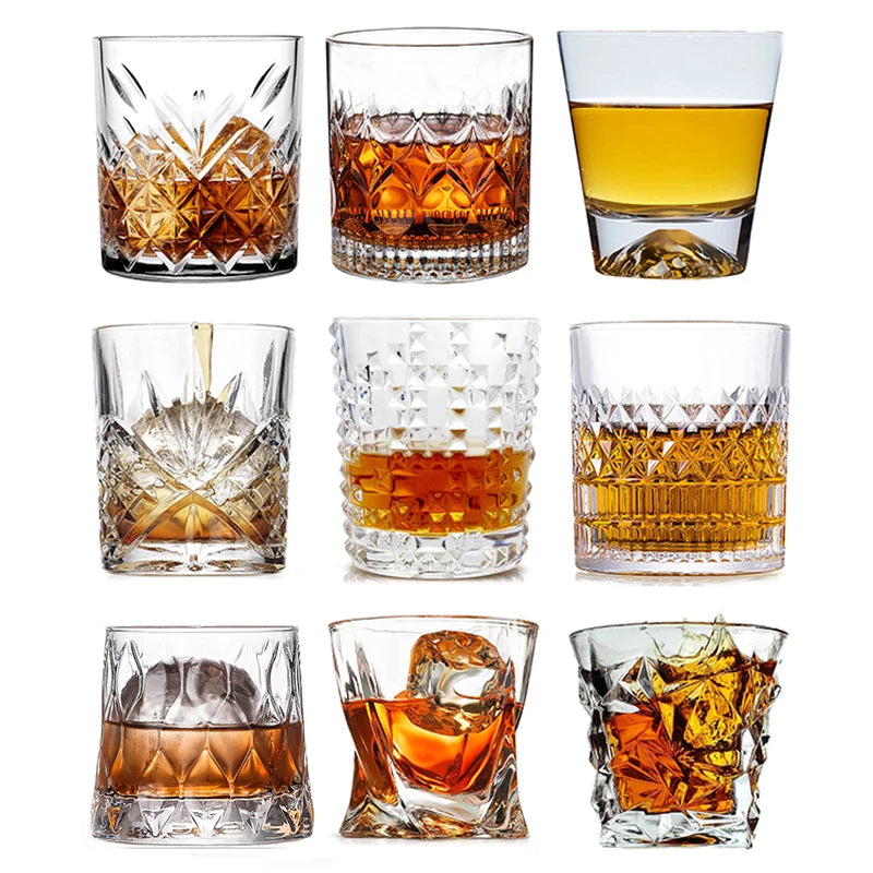 A collection of various whiskey glasses, including rocks glasses and tumblers, showcasing different styles and amber liquid.