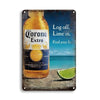 A bottle of Corona Extra beer sits on a rustic metal sign with text instructing to log off and lime in.