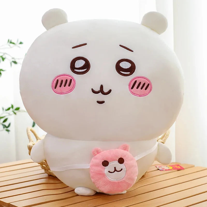 A white Chiikawa Hachiware plush pillow with pink accents, sitting on a wooden surface.