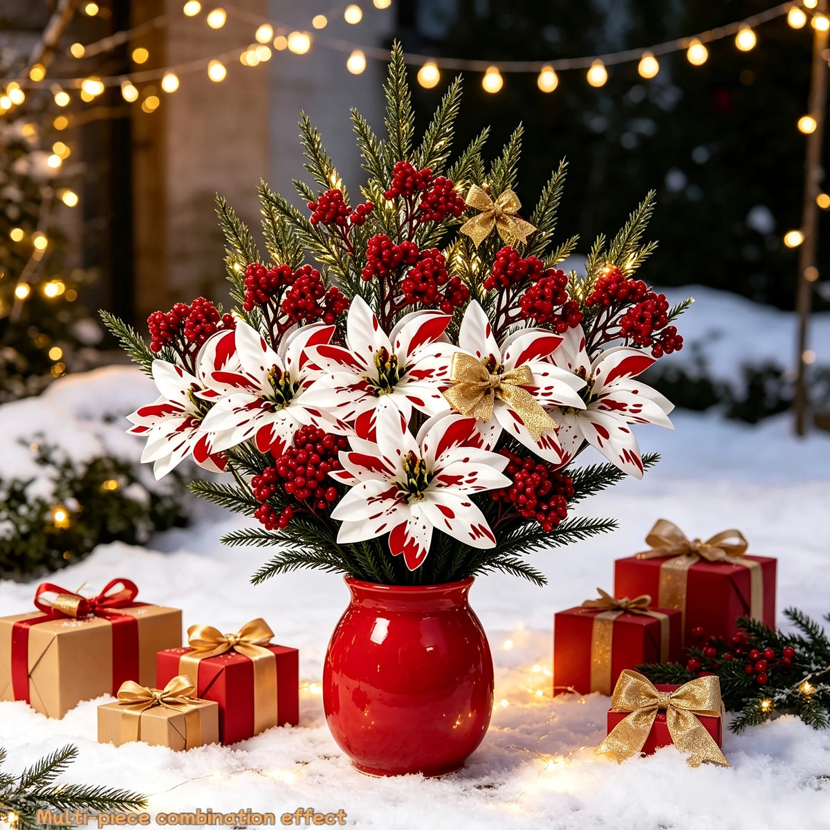 A festive bouquet of red and white artificial flowers in a red vase surrounded by wrapped gifts on a snowy surface.
