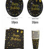 A set of black and gold disposable dinnerware including plates and cups with a happy birthday design.