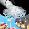 A hand holds a white plastic light string clip, demonstrating the product for use on outdoor lighting.