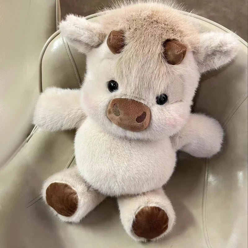 A fluffy white and brown West Highland calf plush toy with large eyes and soft features.