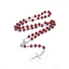 A set of beaded crucifix necklaces featuring small red wood beads on silver chains.