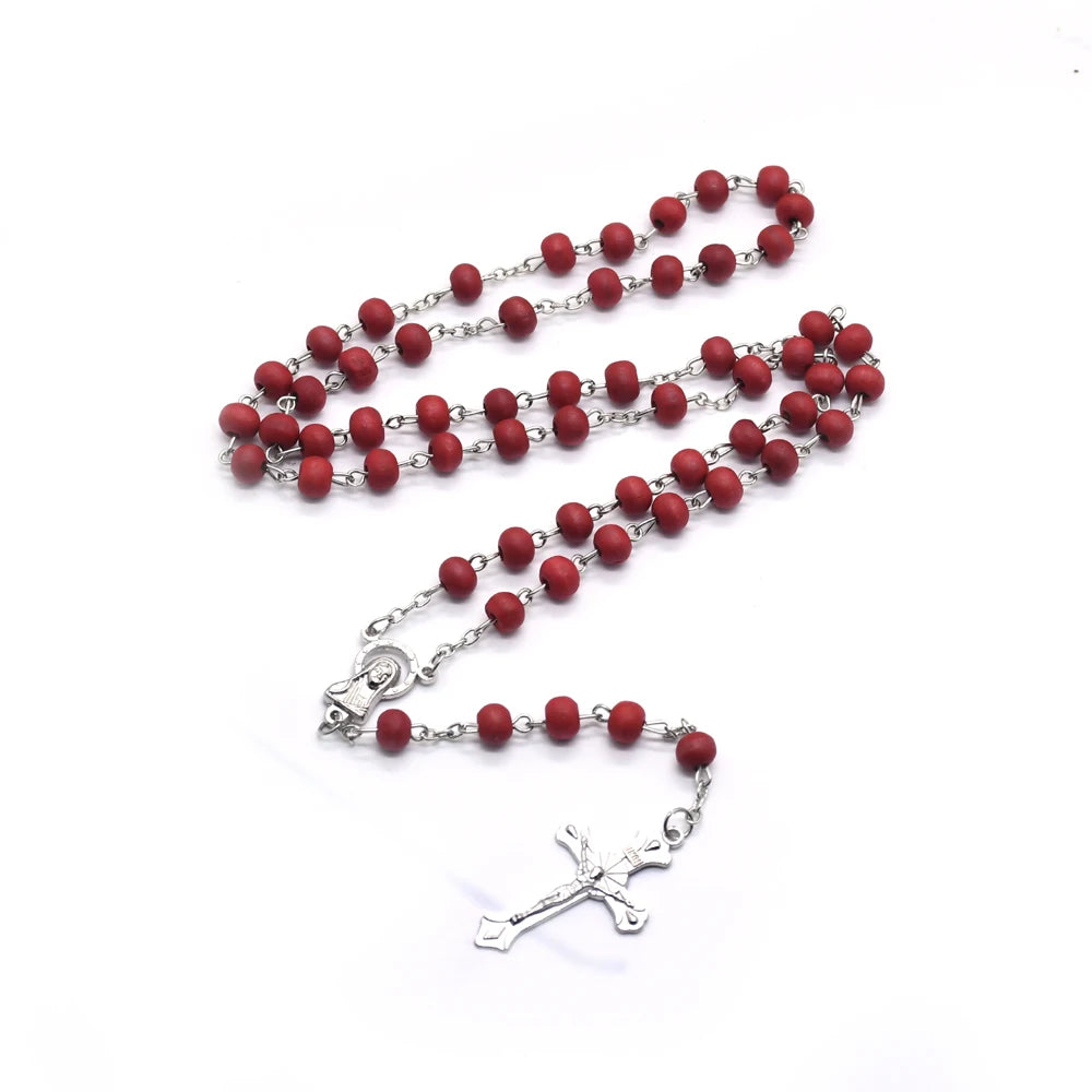 A set of beaded crucifix necklaces featuring small red wood beads on silver chains.
