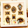 Weiß gerahmte Vitrine mit verzierten goldenen Fotoframes, die Silhouettenbilder halten.