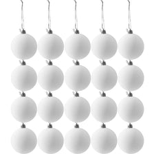 A string of white velvet Christmas ornaments with a flocked finish hanging against a white background.