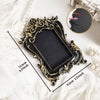 A black vintage baroque resin hanging photo frame with gold accents displayed on a white surface.
