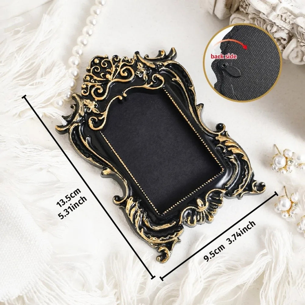 A black vintage baroque resin hanging photo frame with gold accents displayed on a white surface.