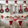 Two festive Christmas wreaths with red ribbon hanging on a white kitchen wall.
