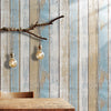 Rustic faux wood peel-and-stick wallpaper featuring vintage blue and white plank design on a wall.