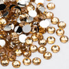 A pile of round flatback resin rhinestones in gold and silver tones for crafts and nail art