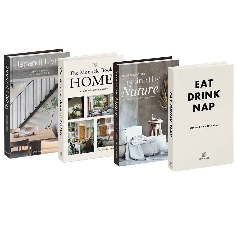 A set of five decorative faux books with titles like The Monocle Book Home and Eat Drink Nap for home decor