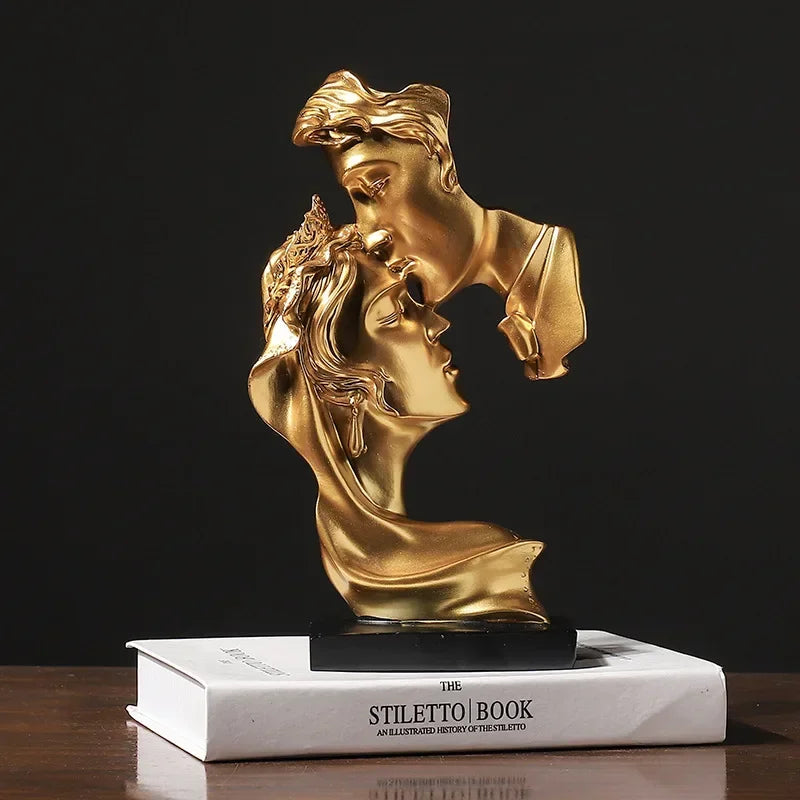Statue en résine dorée représentant deux profils d'amants s'étreignant, exposée sur un livre blanc.