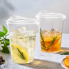 Two clear plastic cups filled with iced tea and garnished with citrus slices and rosemary.