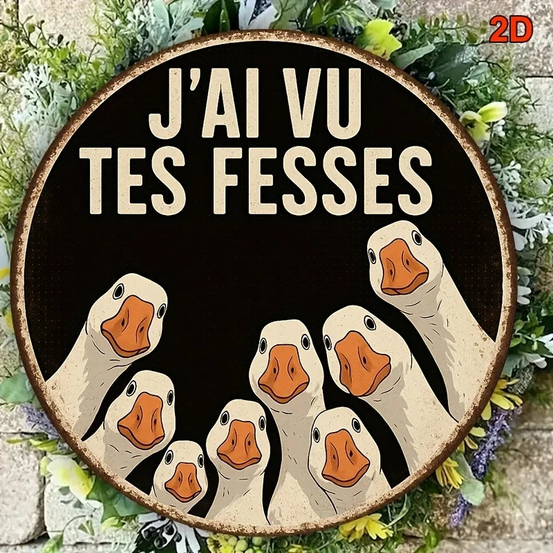 A circular wooden sign featuring multiple stylized duck heads with the text J'ai vu tes fesses