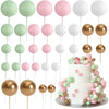 A collection of gold and silver foam ball cake toppers on sticks for party decorations