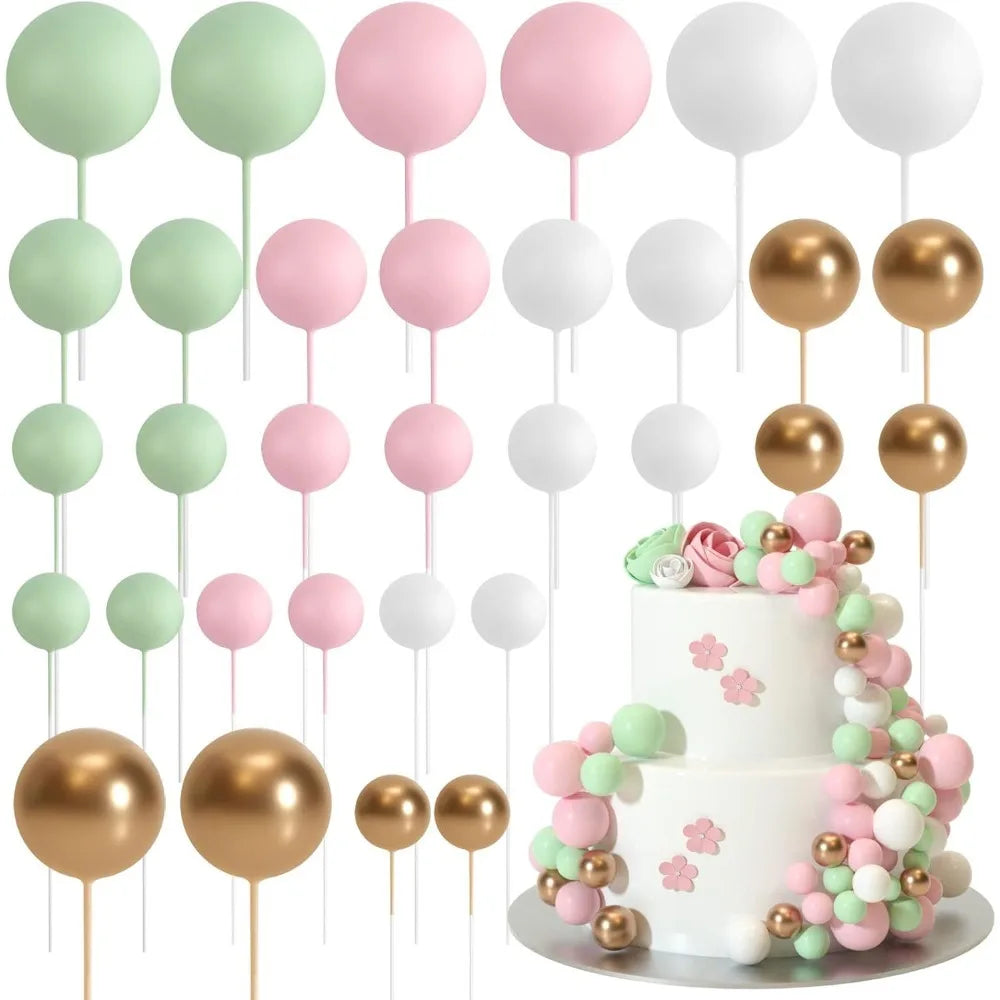 A collection of gold and silver foam ball cake toppers on sticks for party decorations