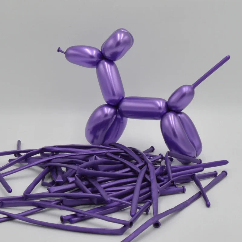 A cluster of glossy purple latex modeling balloons shaped like figures rests on a light gray surface.