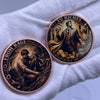 A round copper challenge coin featuring a man in a suit and a sword, with the text To Riches.