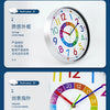 A close-up of a colorful silent wall clock with a dial showing the time, featuring various colored markers and hands.