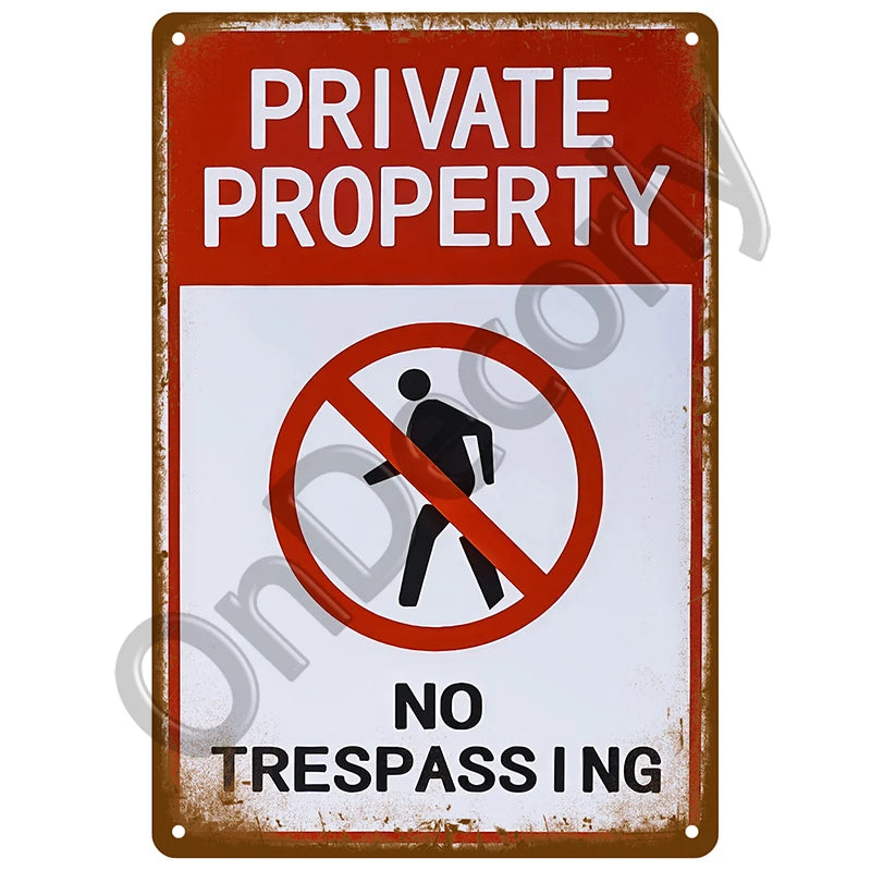 A vintage metal sign with a red background and white text warning against trespassing on private property.