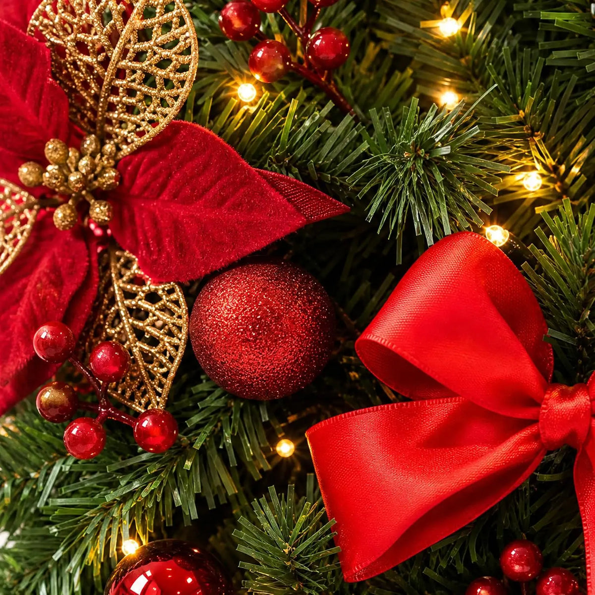 A close-up of a festive Christmas garland featuring red ribbon, gold accents, and sparkling ornaments on green pine branches.