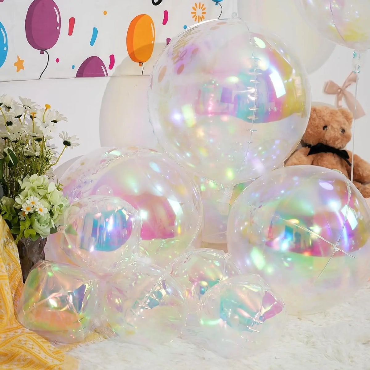 A collection of iridescent holographic round foil balloons in various shades and sizes for party decor.