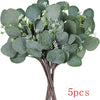 A bundle of artificial eucalyptus stems with small white flowers for home decor