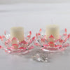 A crystal lotus candle holder with a white candle and pink glass petals.