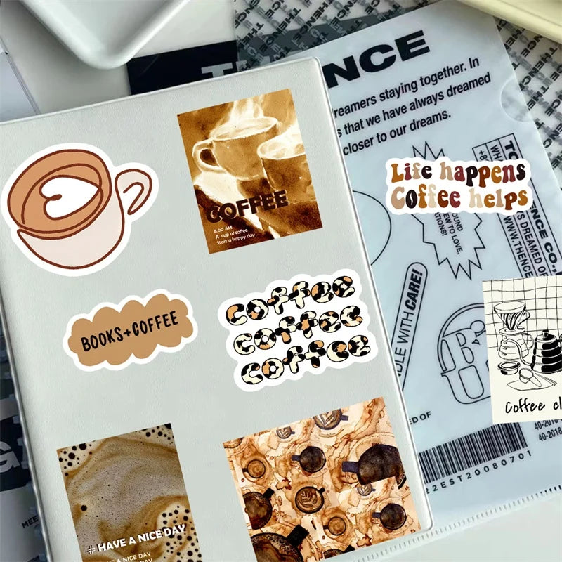 Primer plano de una página de cuaderno con varios stickers temáticos de café y libros.