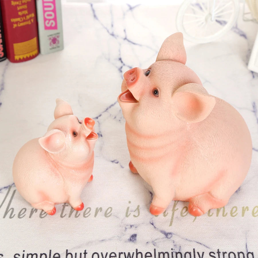 A small, adorable pink resin piggy bank with large ears sitting on a white surface.