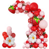A vibrant balloon arch wreath featuring red and pink balloons with strawberry accents.