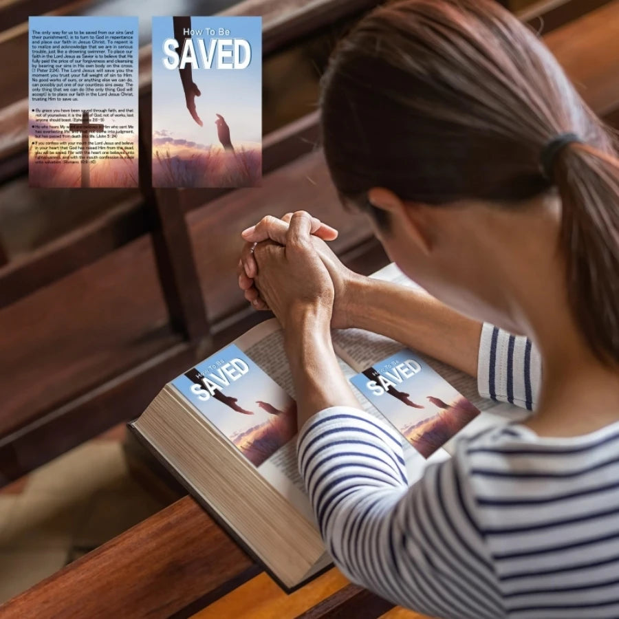 A person is looking at inspirational prayer cards titled How To Be Saved and Saved, holding a book.