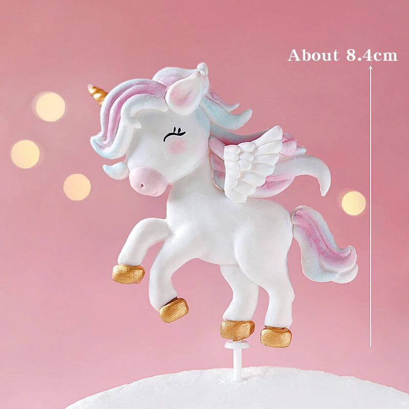 A white unicorn cake topper featuring pink accents and gold details on a white cake.