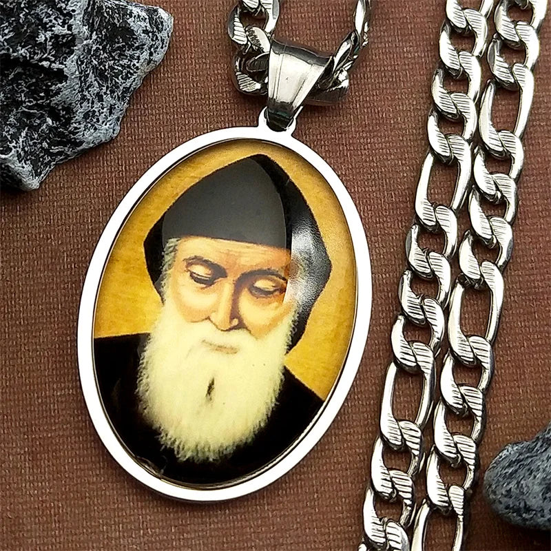 A silver stainless steel pendant necklace featuring a portrait of Saint Charbel glass medal in an oval frame.