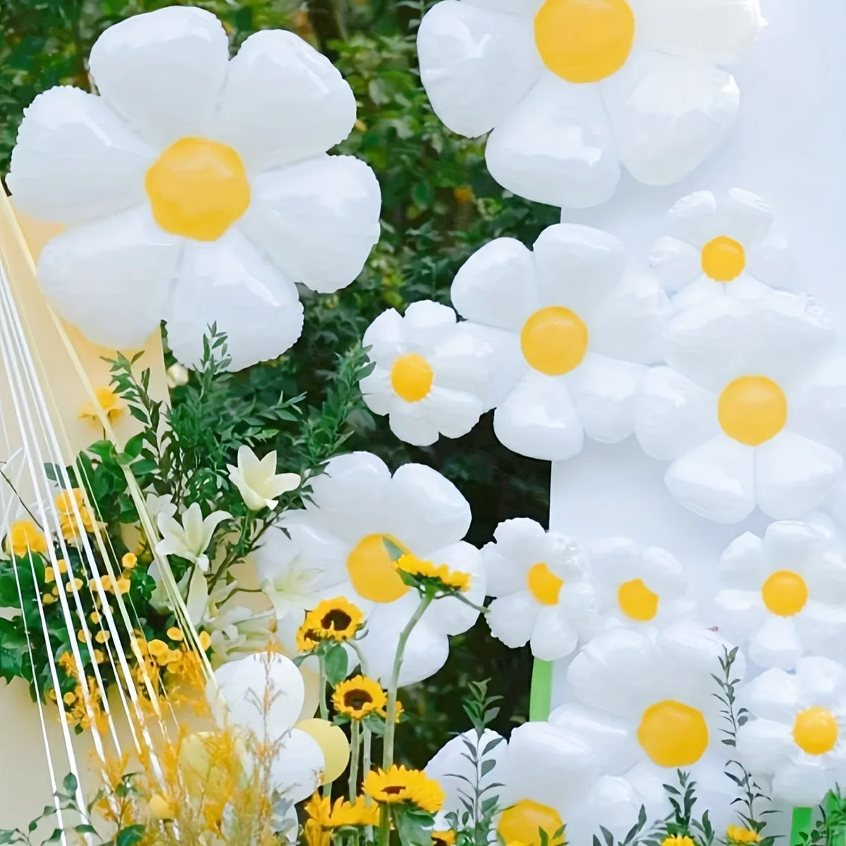 A close-up of white and yellow aluminum foil balloons arranged in a floral pattern.