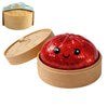A red, glittery, face-shaped squishy toy is shown in its wooden container and a separate lid.