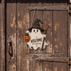 A wooden ghost door hanging featuring a witch hat and a broomstick design on an old wooden door.