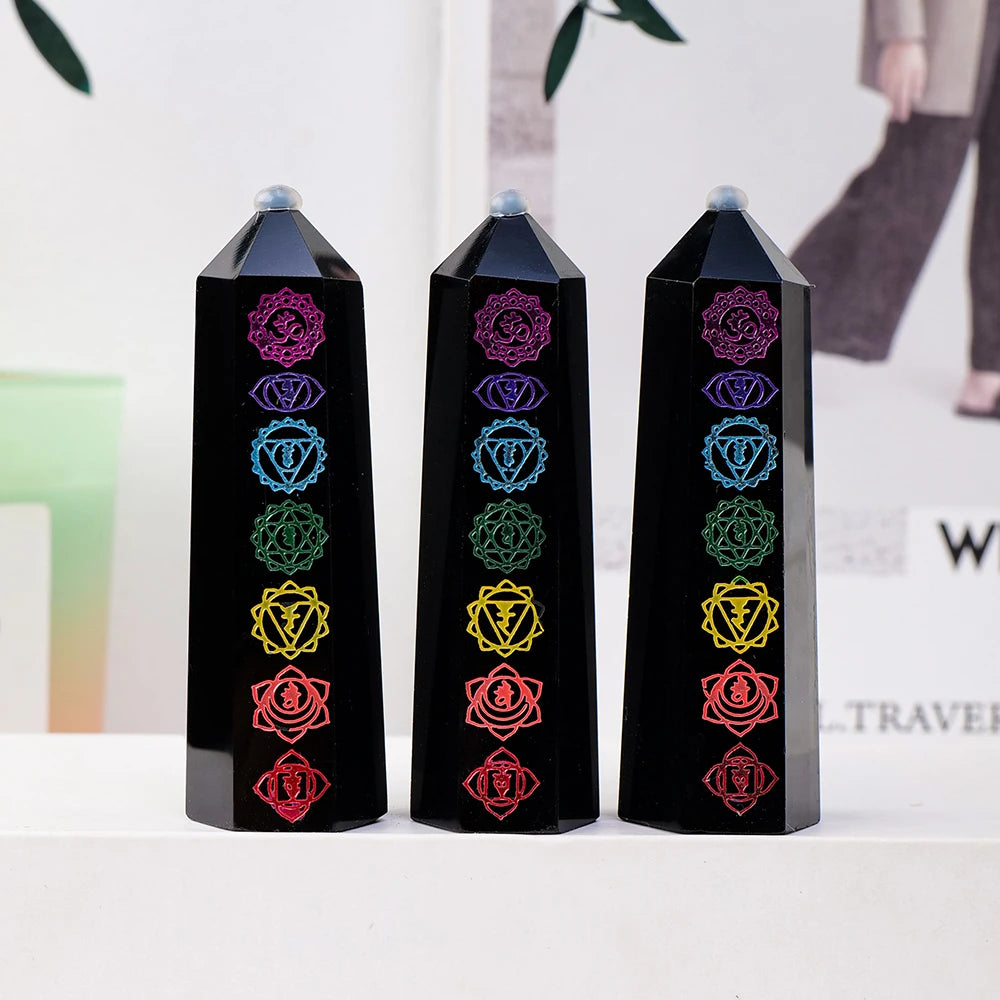 Three black obsidian crystal towers with colorful gemstone points displayed on a white surface.