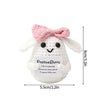 A handmade white crochet bunny doll with pink ears and a slogan stitched on its body.