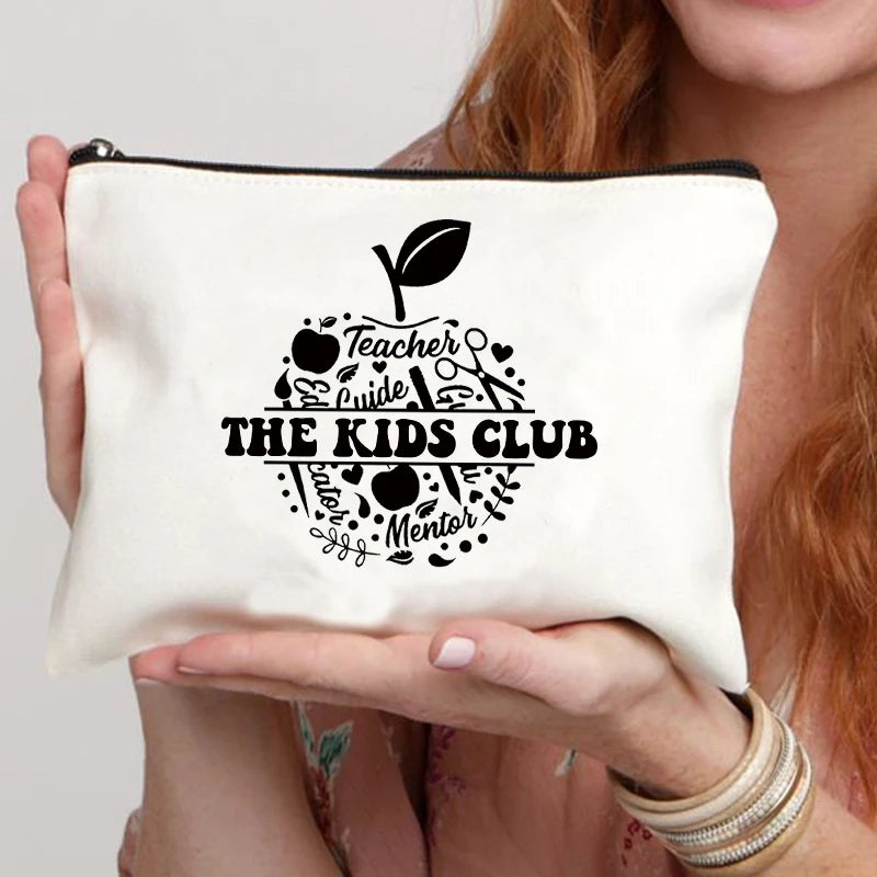 A cream-colored canvas makeup bag featuring a black silhouette of a leaf and the text THE KIDS CLUB