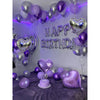 A purple and silver birthday decoration featuring metallic and heart-shaped balloons and a large lettering sign.