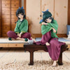 A collectible PVC figure of Maomao from The Apothecary Diaries sitting on a wooden bench.