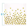 A sheet of white paper covered with numerous gold polka dot confetti pieces.