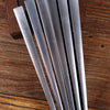 A set of five silver titanium alloy folding hand fans arranged diagonally on a wooden surface.