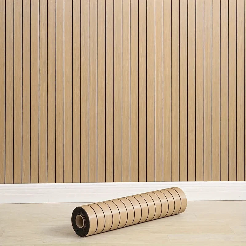 Roll of self-adhesive 3D wood grain wall panels lying on a light wooden floor.