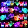 A collection of various shot glasses and tumblers illuminated with colorful LED lights for parties